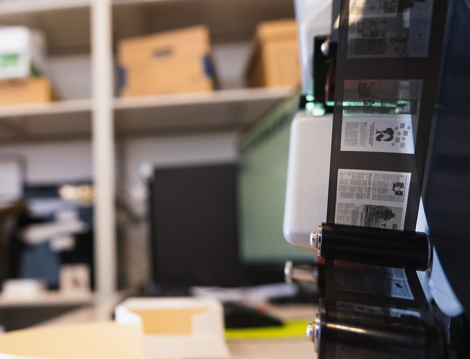 newspaper pages on microfilm threaded through the pulleys of a scanner