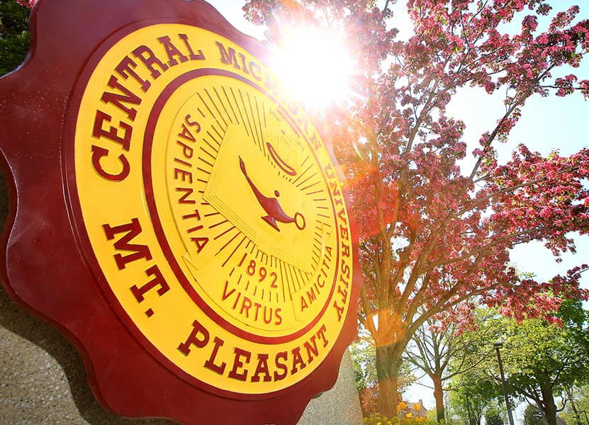 maroon and gold CMU seal  with a tree in the background