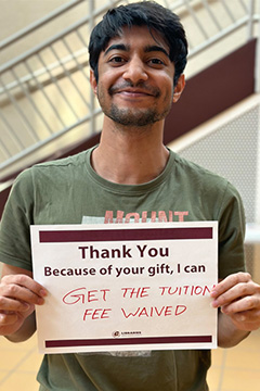 Library Scholarship Recipient Riteesh Mandi holding a sign that reads 