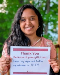 RRHheadshot Image_200x250 a smiling woman holding a sign that says, thank you. Because of your gift, I can finish my degree and further my education in STEM.