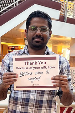 Library Scholarship Recipient Sai Chand Veapally holding a sign that reads 