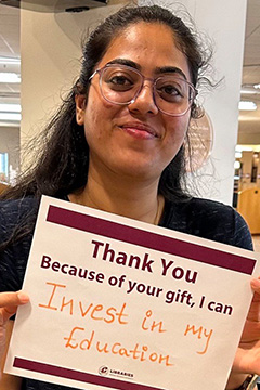 Library Scholarship Recipient Tejaswini Manohar holding a sign that reads 