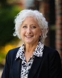 a photo of Provost Paula Lancaster in front of Grawn Hall