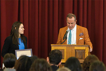 A man standing at a podium and a woman standing next to him.