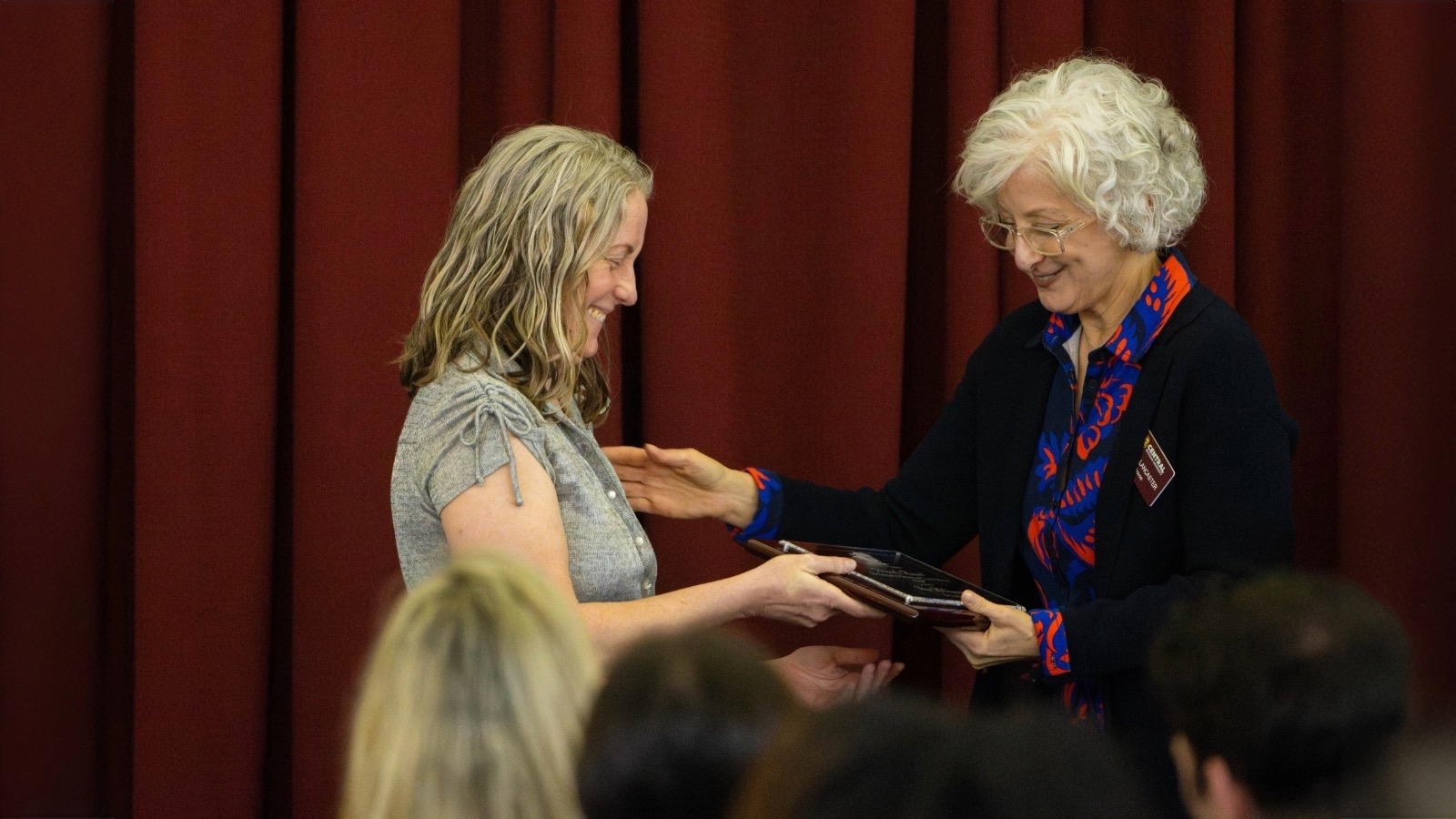 A woman receiving a certificate from another woman.