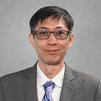 Keejae_Hong_200x200 Keejae Hong in a professional headshot, wearing glasses, a gray suit, and a striped tie against a neutral background.