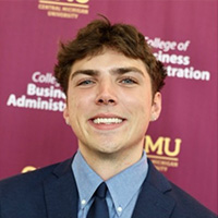 Koby_Rhymer_200x200 Koby Rhymer smiling in a professional headshot, wearing a suit and tie with a CMU backdrop.