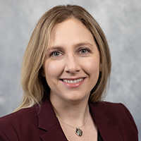 Lauren_Zettel_200x200 Lauren Zettel smiling in a professional headshot, wearing a maroon blazer against a neutral background.