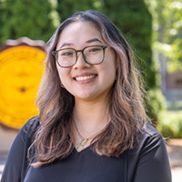 Lindsey_Nguyen_200x200 Lindsey Nguyen smiling in a professional headshot, wearing glasses outdoors with the CMU seal in the background.