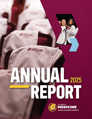 White medical coats draped over chairs with College of Medicine, Central Michigan University logo, accompanied by a photo of two people joyful, making a heart with their hands. Bold text reads Annual Report 2025 on a maroon background.