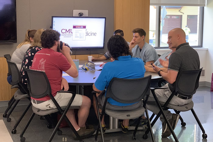 Emergency medicine residents gathered in a round table discussion