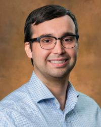 a man wearing glasses and smiling