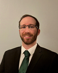 RobertCalleja_200x250 a man wearing glasses and a suit and tie.