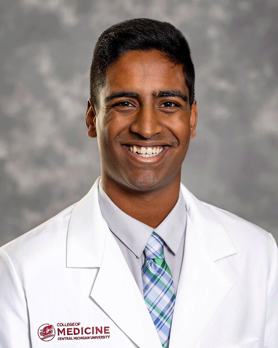 Peddiboyina, Manas 200 x 250 web A male CMU College of Medicine medical student wearing a blue and green plaid tie and his white coat as he smiles for the camera.