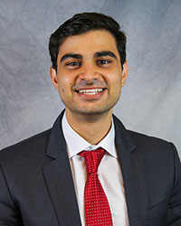 Headshot of Wasef Al-Khateeb wearing a dark gray suit with a white dress shirt and a red necktie.