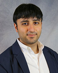 Headshot of John Jarad wearing a blue suit coat over a white shirt.