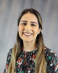 Headshot for Harpreet Grewal wearing a black print top.