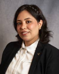 A woman in a white button down and black suit coat.