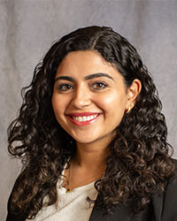 Mary Attalla has long curly hair smiling