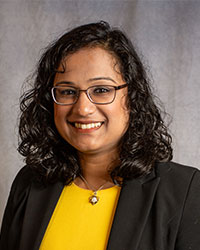 Archita Chandra is wearing glasses and a black blazer