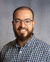 Assem Ellythy has a beard and glasses smiling