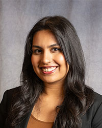 Amritpal Garha is wearing a black blazer and has long, dark hair.