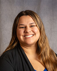 Kendal Highhouse is wearing a black blazer, smiling.