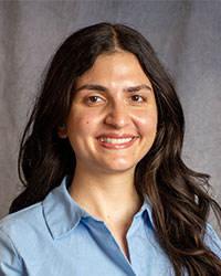 Lema Jaber is wearing a blue button down shirt and has long dark hair.