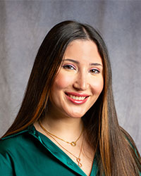 Tamara Kadi has long hair wearing a green shirt