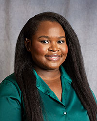 Ekeoma Onuoha is wearing a satin teal button down shirt.