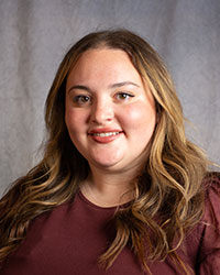Allison Vlk is wearing a burgundy blouse in a professional photo.