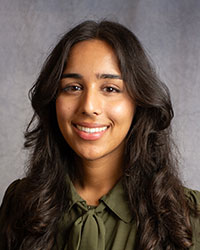 Mehdia Zaidi wearing a green blouse in a professional headshot.