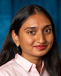 a woman with long hair wearing a pink shirt