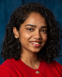 a woman with curly hair wearing a red sweater