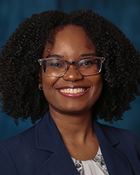 a woman wearing glasses and a blue blazer