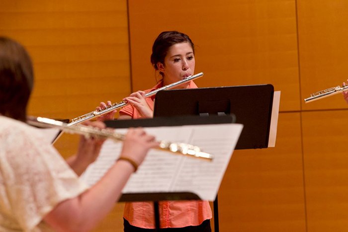 Students practicing playing their flutes.