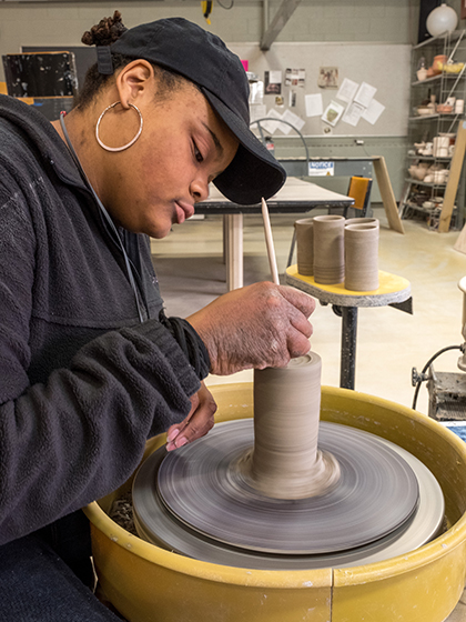 Student working on a pottery wheel