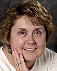 Headshot of Monetta Richey Harr with a dark grey backdrop.