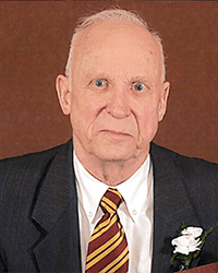 Headshot of Alan D Stuart in a suit and tie in front of a dark gold backdrop