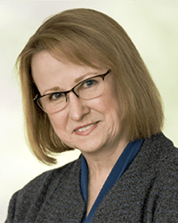 Headshot of Sarah Opperman in front of a soft green backdrop
