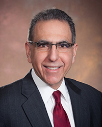 Headshot of Steve Serkaian in front of a pale mauve backdrop.