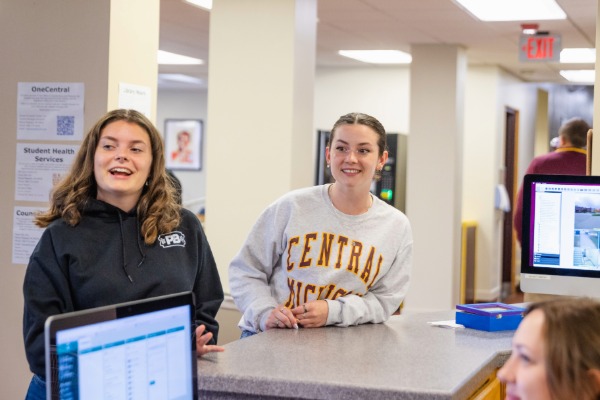 Two girls standing next to a counter inside Sweeney Hall.