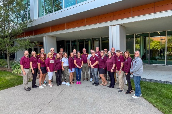 A group of TSE faculty posing for a photo in front of the EHS building.