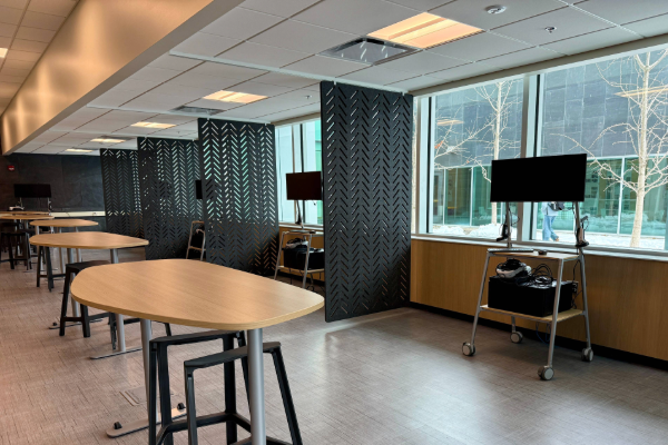 Image of an clean room. There are three counter-height tables and computers are rolling carts. Felt dividers create bays for the XR Lab