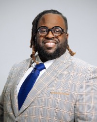 Professional headshot of LaVonte Heard with a grey background behind him.