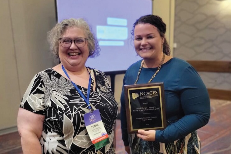 Counseling faculty pose with the NCACES plaque award.