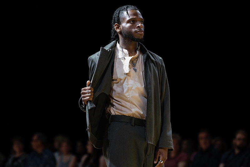 Model in men's clothing on runway during the Threads fashion show.