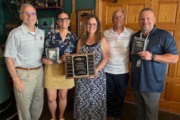 Multiple faculty members holding the award plaques at the Hall of Fame Awards event.