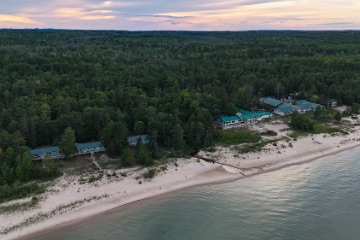 Aerial view of the Beaver Island Research Center near the water at sunset.