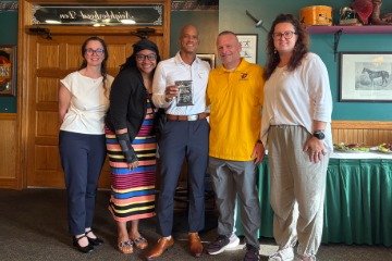Foley holding his award plaque and posing for a photo with the Ed.D. Alumni Board.